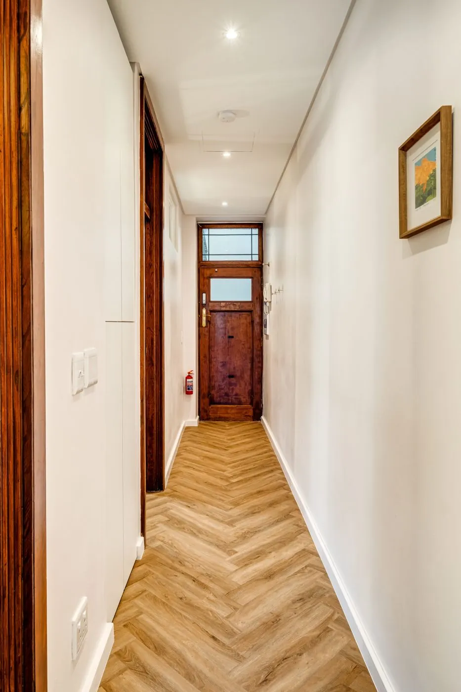 Hallway with herringbone floor and the original wooden front door