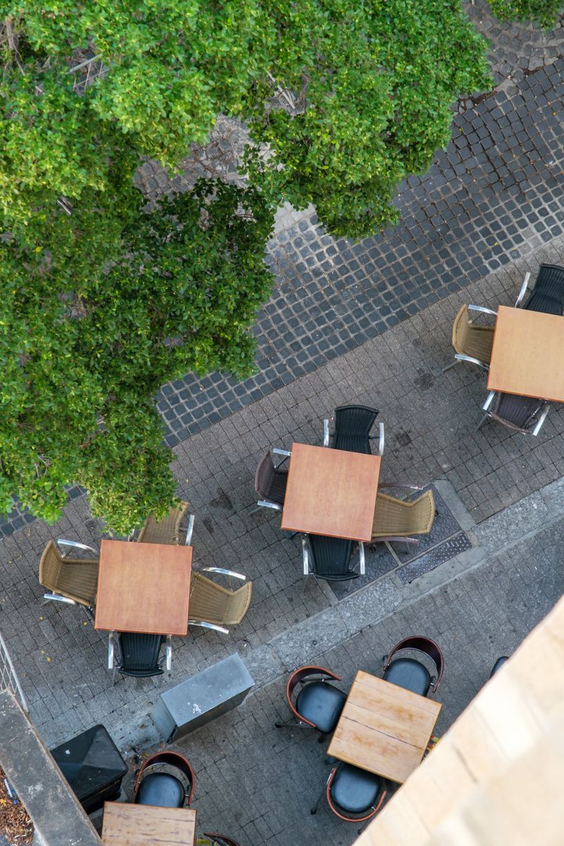 Café tables on the square under the plane trees, seen from above